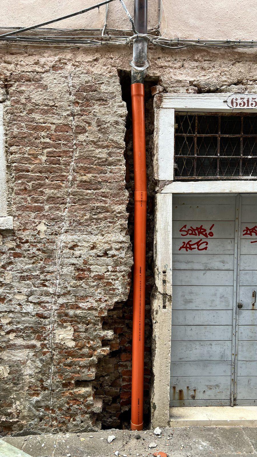 Rifacimento pluviale su facciata veneziana con mattoni a vista